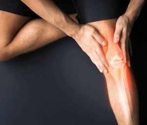 Man sitting on the floor clutching sore knee - benefits of ozone therapy for joint pain